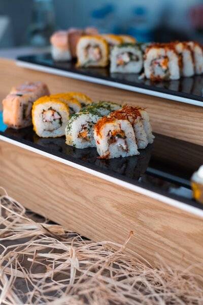 Sushi-Buffet im Sherwood Exclusive Kemer Hotel mit verschiedenen Sushi-Rollen auf schwarzen Platten.