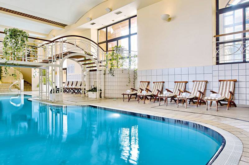 Innenpool im Corinthia St George's Bay Hotel mit Liegestühlen und Treppen
