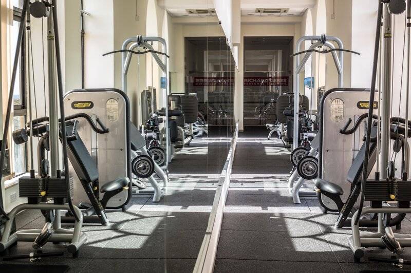 Fitnesscenter im Corinthia St George's Bay Hotel mit verschiedenen Trainingsgeräten.