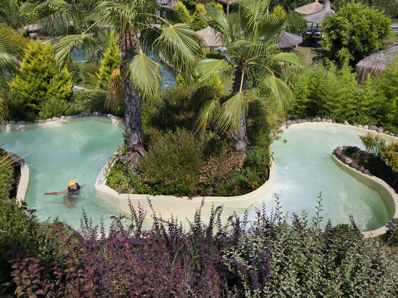 Wasserrutsche im Club Grand Side Hotel, umgeben von Pflanzen und Palmen.