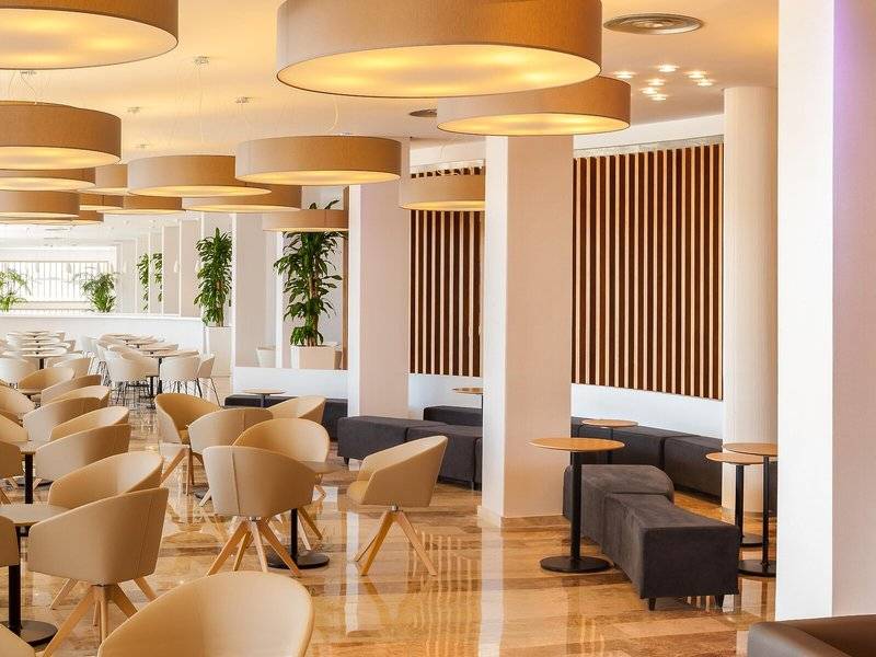 Innenbereich des RH Bayren & Spa Hotels mit runden Deckenleuchten und braunen vertikalen Streifen an der Wand.