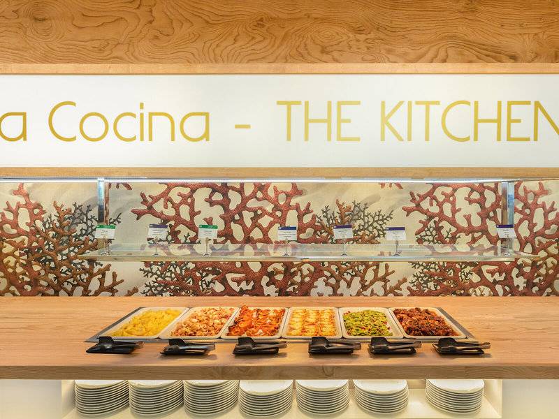 Buffet-Tisch im Hotel RH Bayren & Spa mit verschiedenen Gerichten und einer Tafel mit dem Text 'a Cocina - THE KITCHEN'.