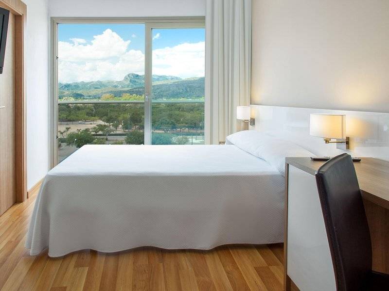 Zimmer im RH Bayren & Spa Hotel mit Bett und Ausblick auf die Berge
