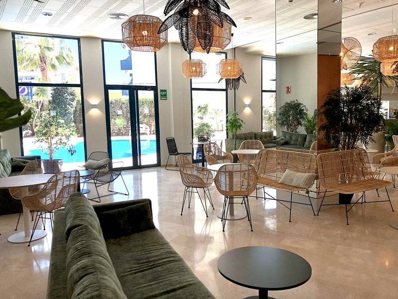 Lobby des Principal Afilliated by RH Hotels mit Möbeln und Pflanzen im Innenraum.