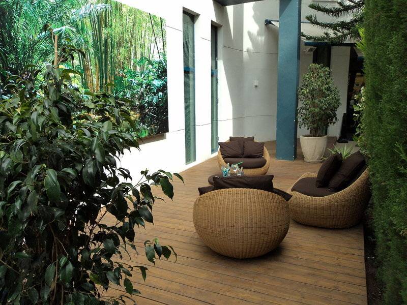 Garten Sitzecke des Principal Afilliated by RH Hotels mit Rattanmöbeln und Pflanzen