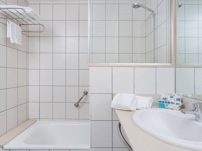 Modernes Badezimmer mit einer Dusche, Badewanne, Handtuchhalter und Waschbecken.