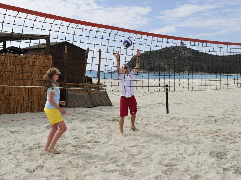 Ein Junge und ein Mädchen spielen Volleyball am Strand des Almar Timi Ama Resort & Spa.