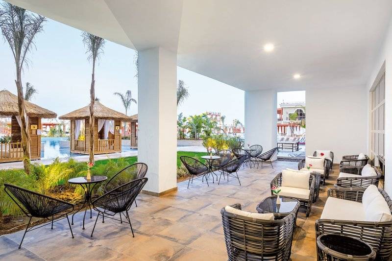 Loungebereich im Sunis Efes Royal Palace Resort & Spa mit Gartenblick und runden Tischen.