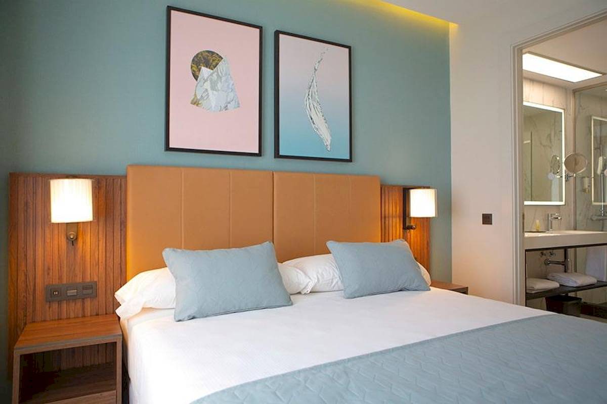 Hotelzimmer im Riu Plaza Espana mit zwei Kunstwerken an der Wand und einem Badezimmer.