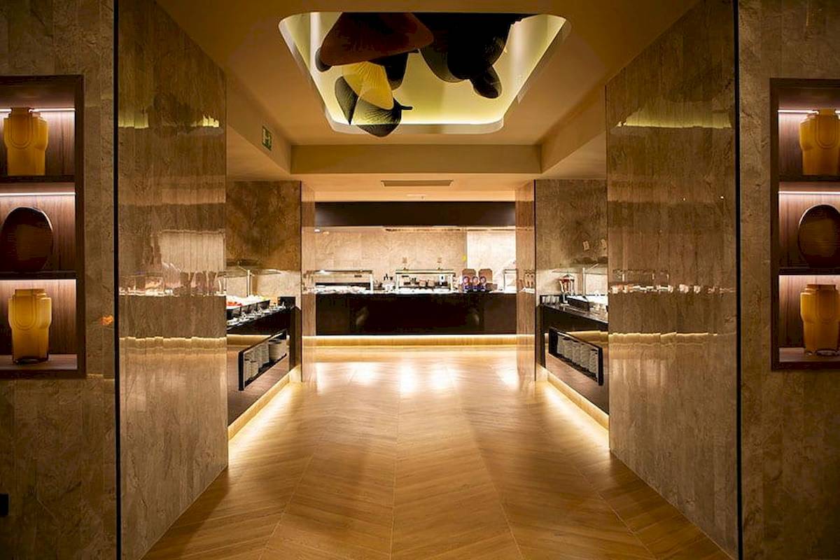 Innenansicht des Restaurants im Riu Plaza Espana Hotel mit Marmorwänden und Holzboden.