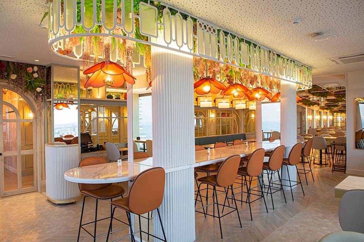Innenbereich der Bar im Riu Plaza Espana mit Marmortischen und orangefarbenen Stühlen.