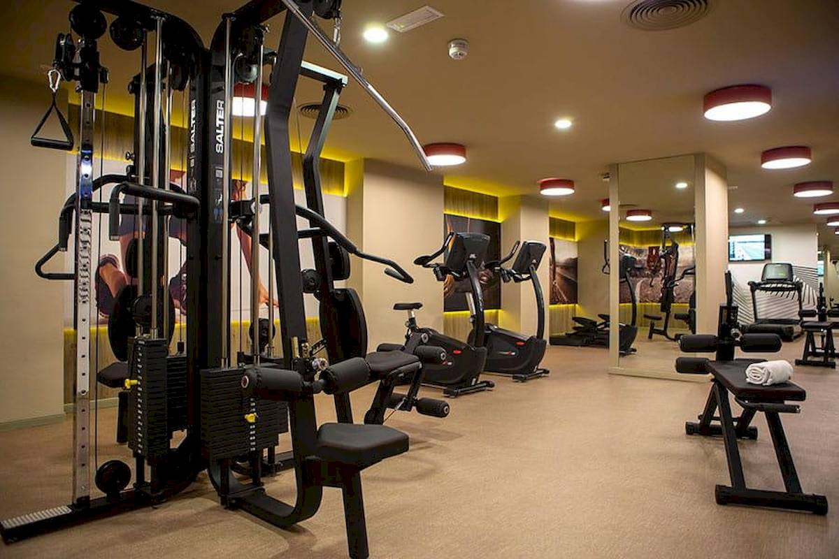 Fitnessstudio im Riu Plaza Espana Hotel mit verschiedenen Geräten und Trainingsbereichen.