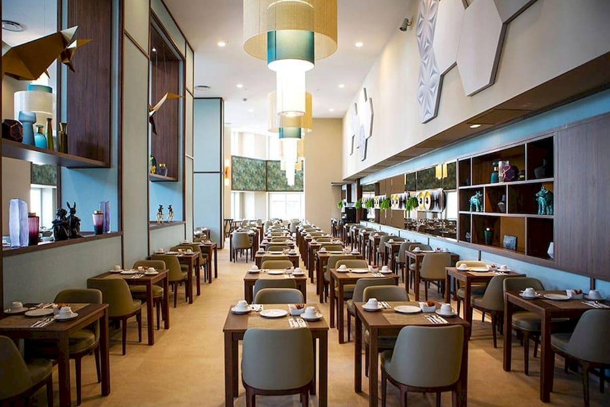 Innenansicht des Restaurants im Riu Plaza Espana Hotel mit gedeckten Tischen und Stühlen.