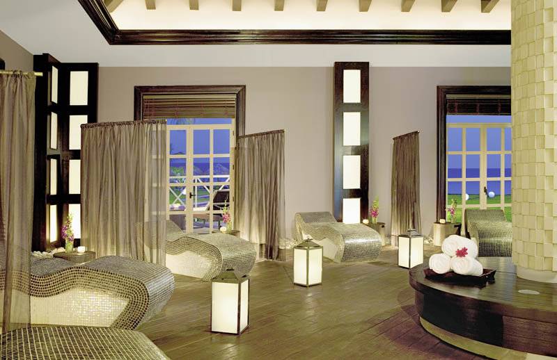 Spa-Lounge im Secrets St. James Hotel mit modernen Möbeln und großen Fenstern.