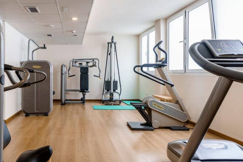 Fitnessraum im ALUA Gran Camp de Mar mit verschiedenen Trainingsgeräten und Yoga-Matten.