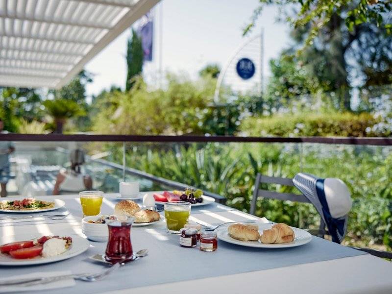 Frühstückstisch auf der Terrasse des TUI BLUE Side Hotels mit verschiedenen Speisen und Getränken.