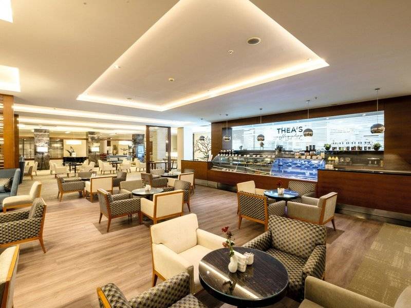 Loungebereich im TUI BLUE Side Hotel mit Sitzmöbeln und einer Theke.