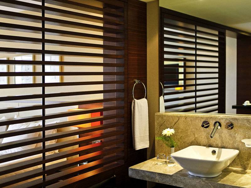 Badezimmer im TUI BLUE Side Hotel mit modernen Möbeln, einem Waschbecken und einem Spiegel.
