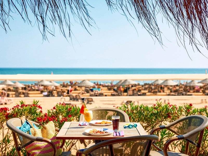 Tisch mit Getränken und Essen im Magic Life Jacaranda mit Blick auf den Strand