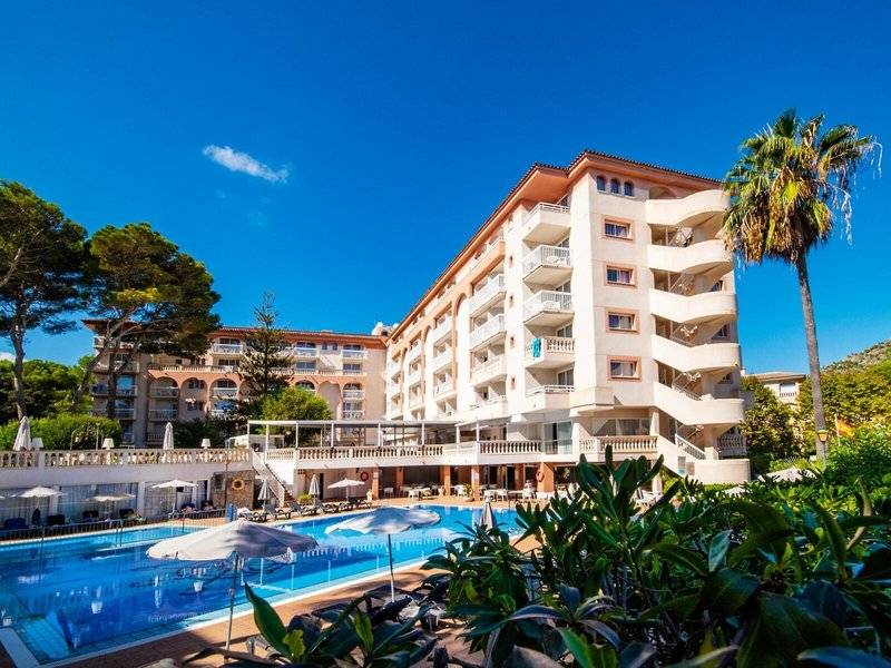 Außenansicht des Canyamel Classic Hotels mit Swimmingpool und Sonnenschirmen.