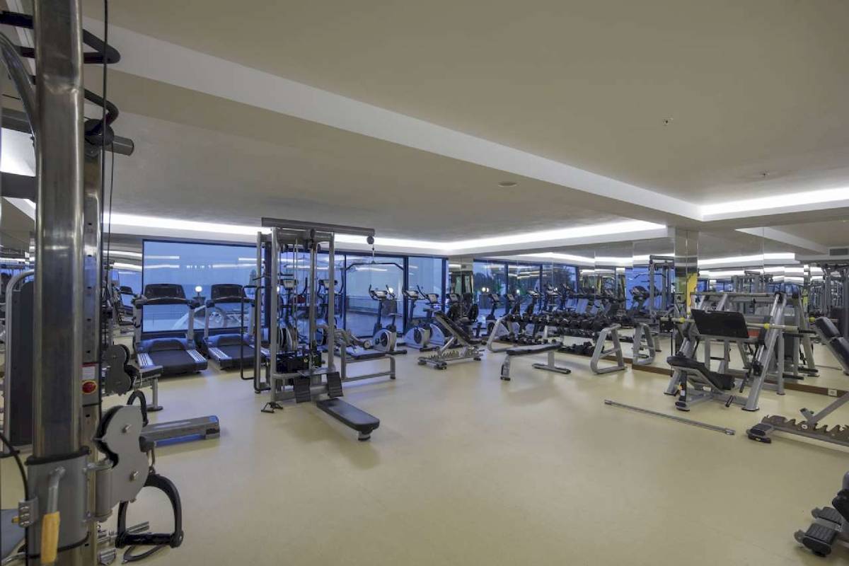 Fitnesscenter im Hotel Granada Luxury Okurcalar mit vielen Trainingsgeräten und großen Fenstern