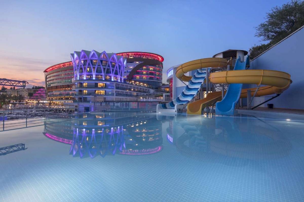 Außenpool neben dem Hotel Granada Luxury Okurcalar mit Wasserrutschen und bunter Beleuchtung.