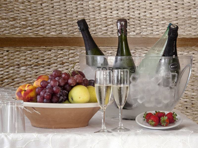 Flaschen im Eisbad mit Obst und Secco auf einem Tisch im Hotel Voramar Formentera