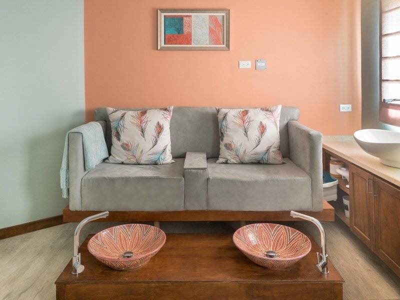 Ein Wohnzimmer mit einem grauen Sofa und zwei dekorativen Waschbecken auf einem Tisch.