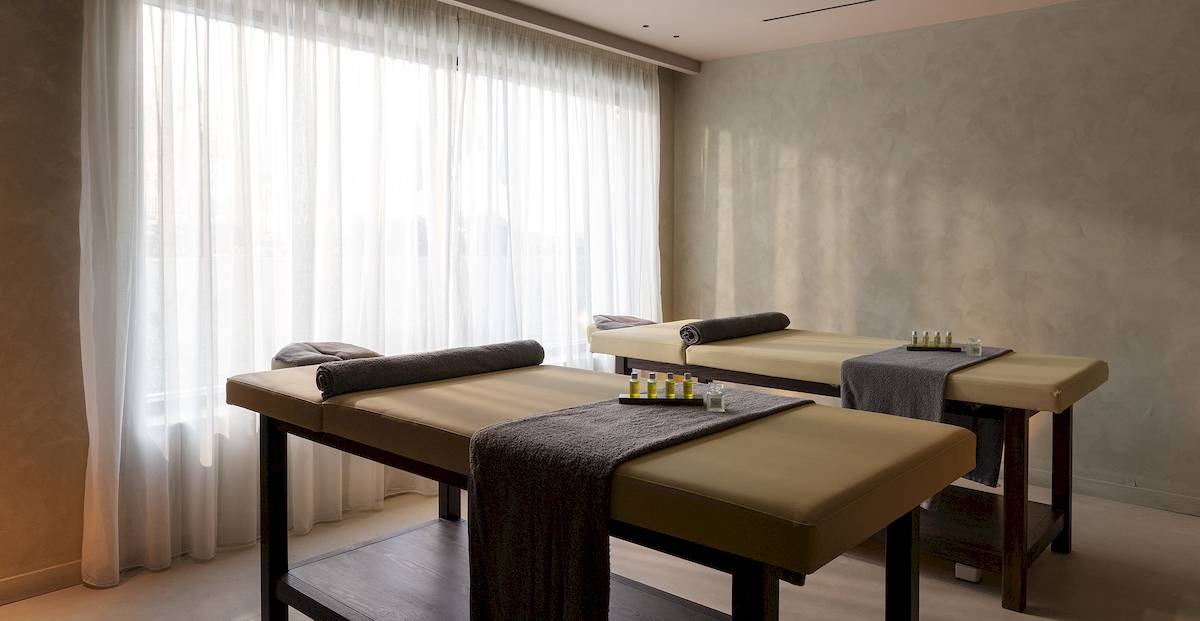 Massagebereich im Helea Lifestyle Beach Resort mit zwei Massageliegen nebeneinander und einer weißen Vorhang.