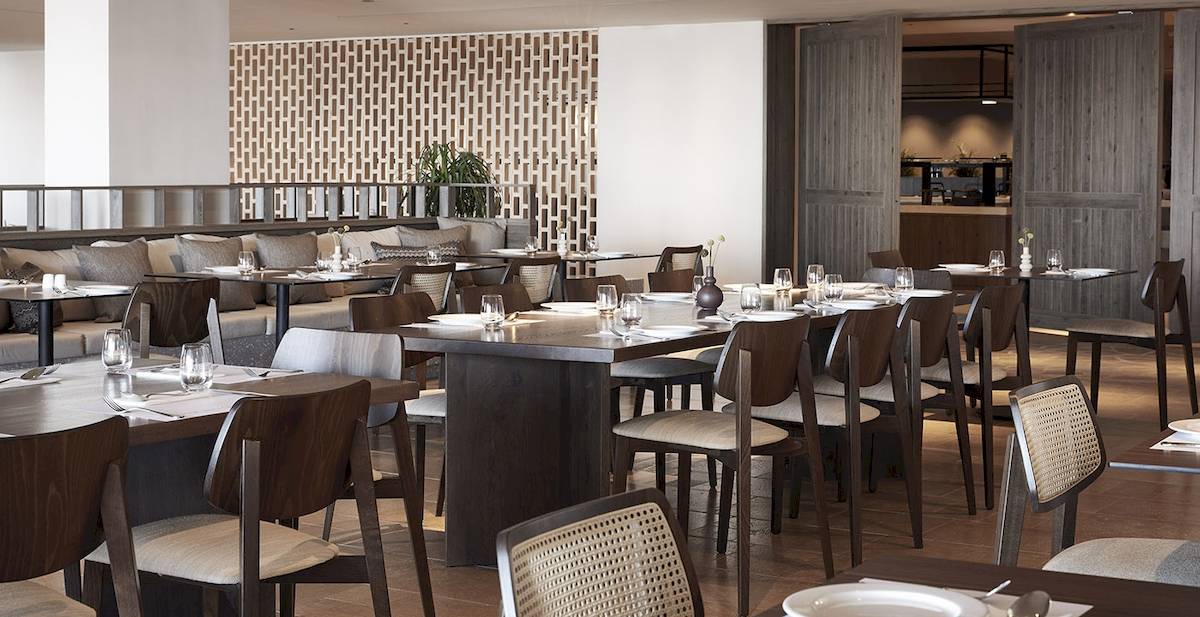 Innenansicht des Restaurants im Helea Lifestyle Beach Resort mit eingerichteten Tischen und Stühlen.