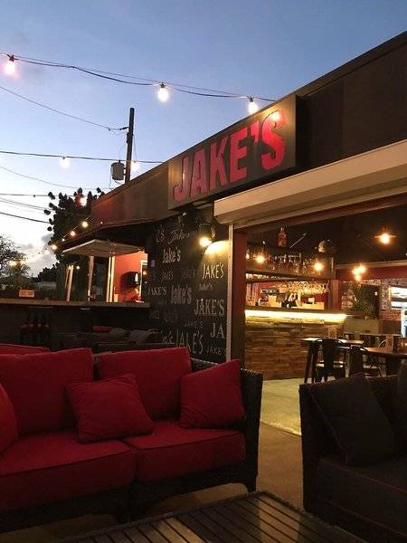 Abendstimmung in Jake's Bar mit roten Sofas und Beleuchtung.