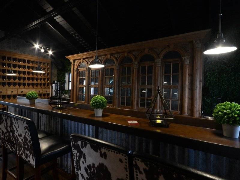 Hotelbar im Sugar Bay Barbados mit Barhockern, Pflanzen und alten Holzelementen.