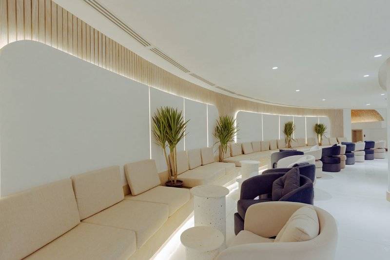 Innenbereich des Sunrise Anjum Resorts mit weißen Wänden, Sofas und Pflanzen.