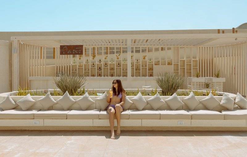 Frau in Bikini sitzt vor der Bar im Sunrise Anjum Resort