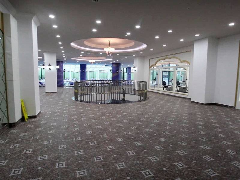 Lobby des Alan Xafira Deluxe Resort & Spa mit geometrischem Bodenmuster und zentraler Wendeltreppe