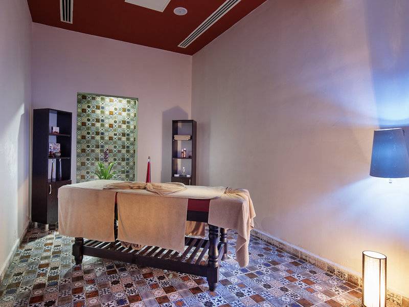Massageraum im Alan Xafira Deluxe Resort & Spa mit Tisch, Kerzen und dekorativen Wandfliesen.