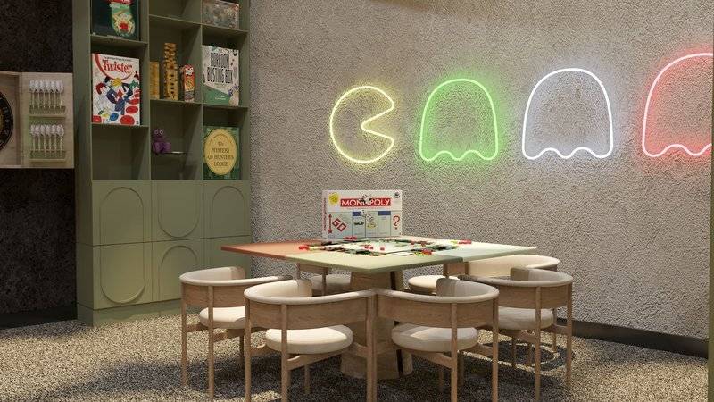 Spielzimmer im Ethno Belek Hotel mit grünen Möbeln und leuchtenden Pac-Man-Leuchten an der Wand.