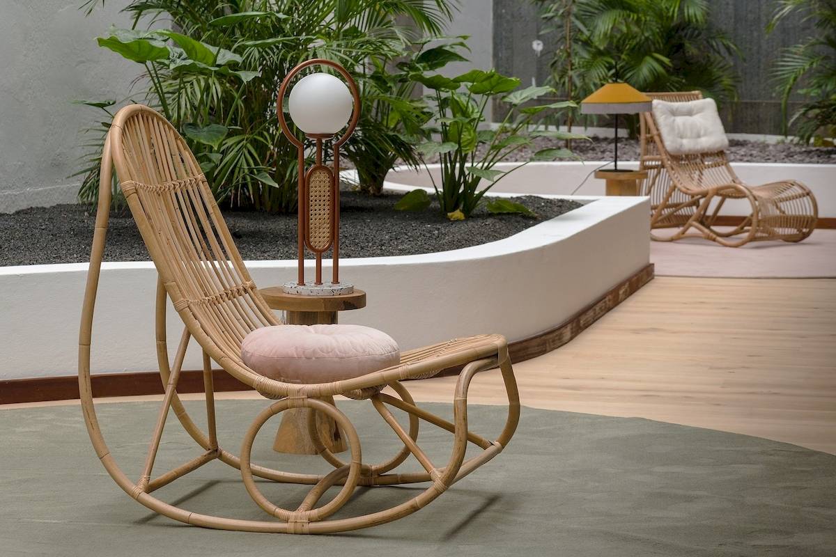 Im Garten des Plus Fariones Suite Hotels steht ein geschwungener Rattansessel.