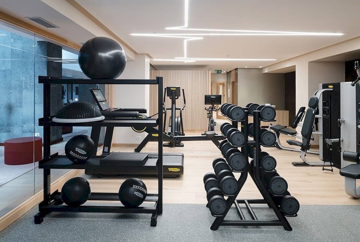 Fitnessbereich im Plus Fariones Suite Hotel mit diversen Trainingsgeräten und Hanteln.