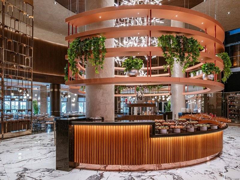 Buffet Tisch im Kirman Leodikya Resort mit grünen Pflanzen und Marmorboden.