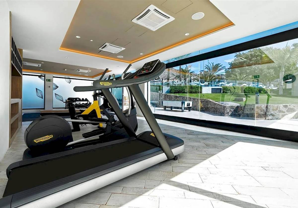 Fitnessbereich im H10 Costa Mogan Hotel mit modernen Laufband und anderen Geräten.