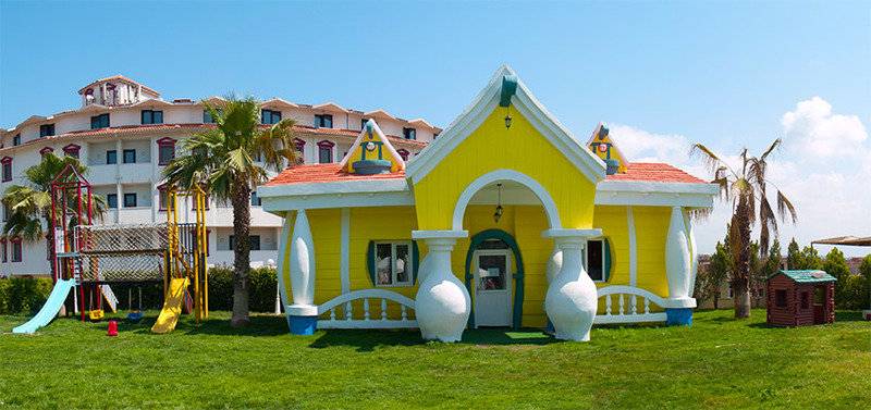 Gelbes charakteristisches Haus im Garten des Cesars Side Hotels