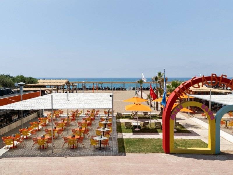 Strandterrasse des Megasaray Resort Side mit Tischen, Stühlen und Sonnenschirmen.