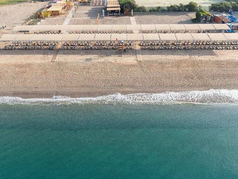 Luftaufnahme des Megasaray Resort Strands mit vielen Sonnenliegen und Gebäuden