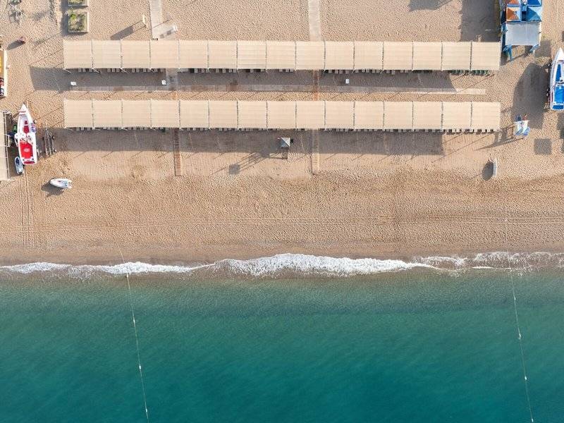 Luftaufnahme des Megasaray Resort Side Strandes mit Sonnenschirmen und Booten