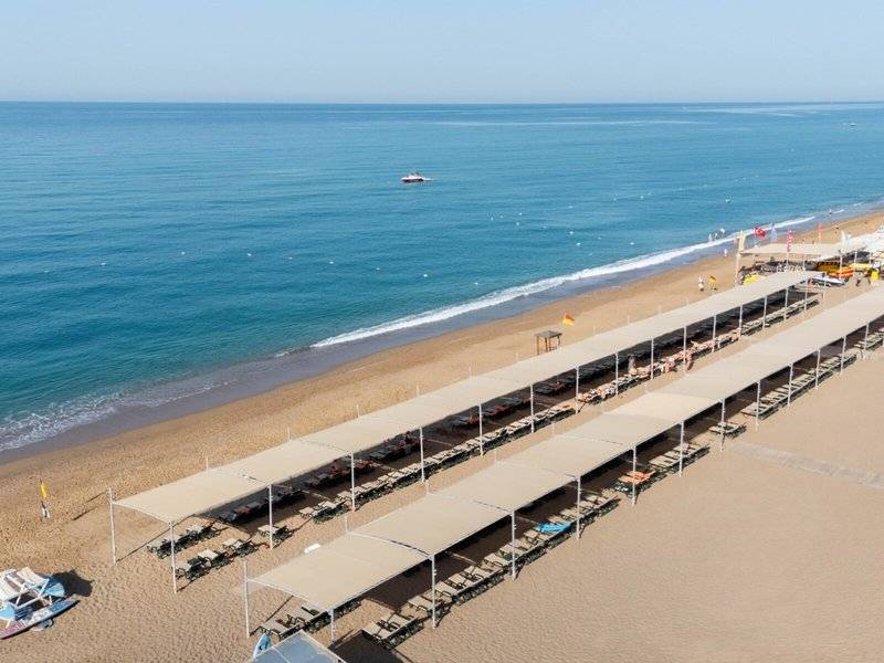 Luftaufnahme des Megasaray Resort Strands mit vielen Liegen unter Sonnenschirmen