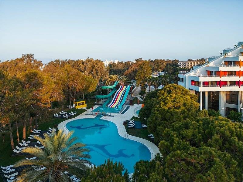 Luftaufnahme des Megasaray Resort Side mit Pool und Wasserrutschen, umgeben von Bäumen und Liegestühlen.