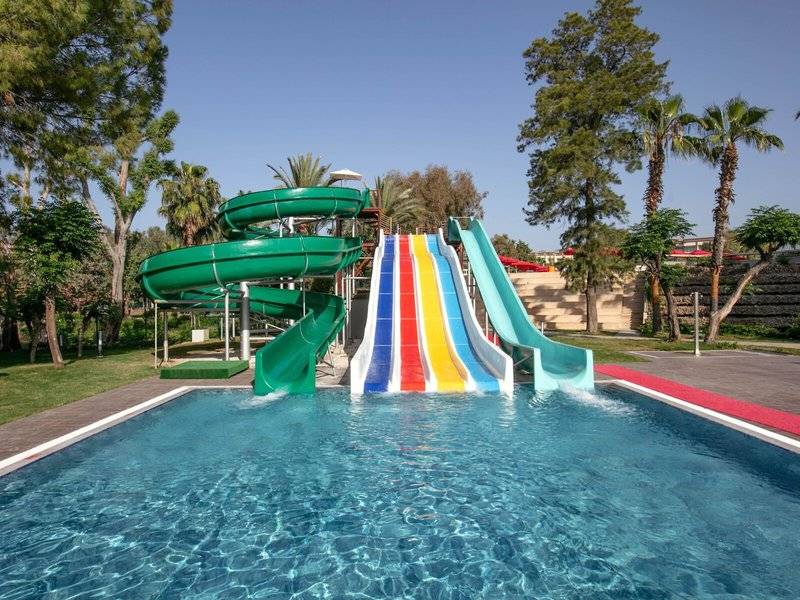 Wasserrutschen im Megasaray Resort Side mit grünen und bunten Rutschen neben einem Pool.
