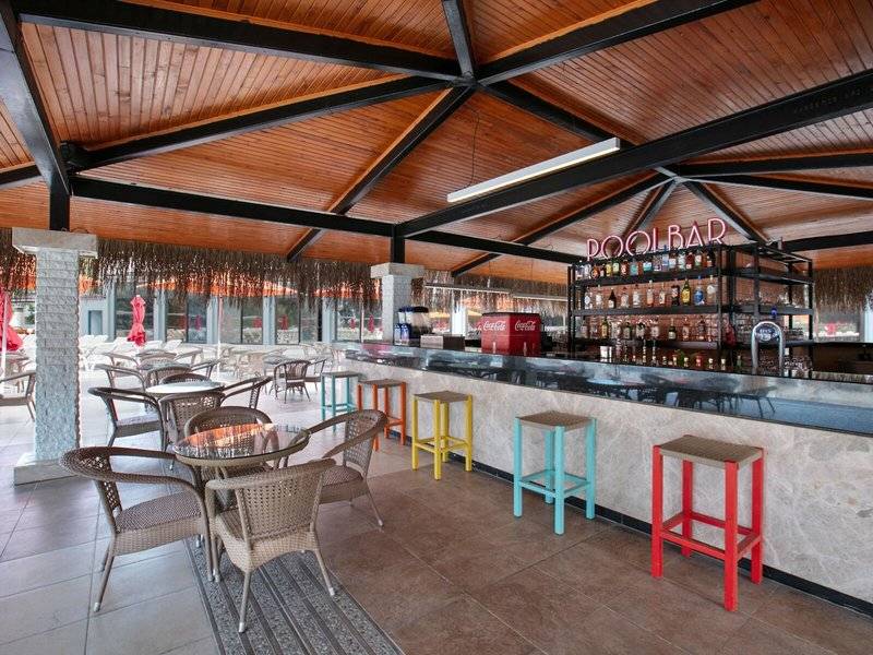 Innenansicht der Poolbar des Megasaray Resort Side mit Holzdecke, Bartheken und bunten Hockern.