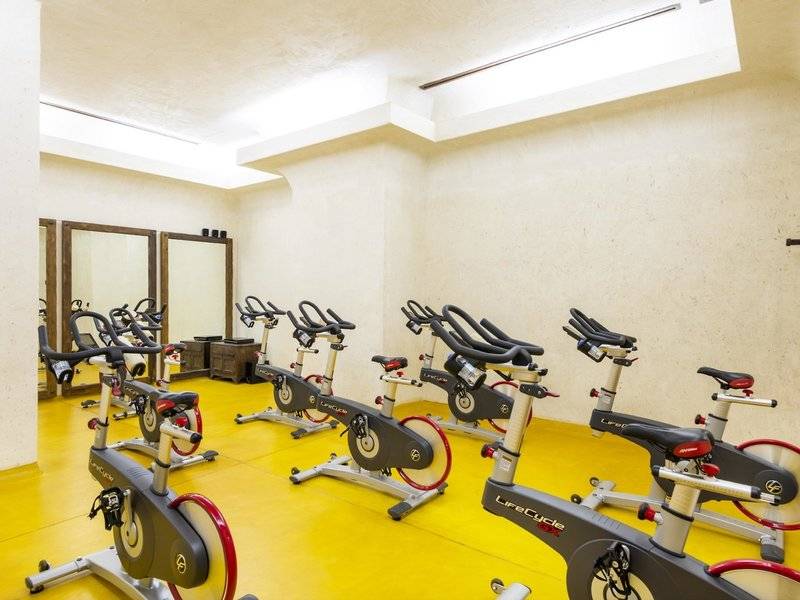 Fitnessstudio im Sharq Village und Spa mit mehreren Spinrädern und Spiegeln